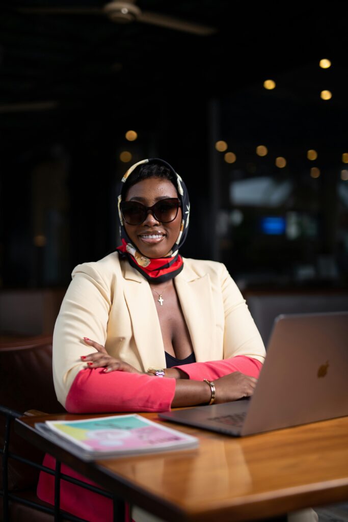 Confident businesswoman with laptop in an elegant indoor office setting.