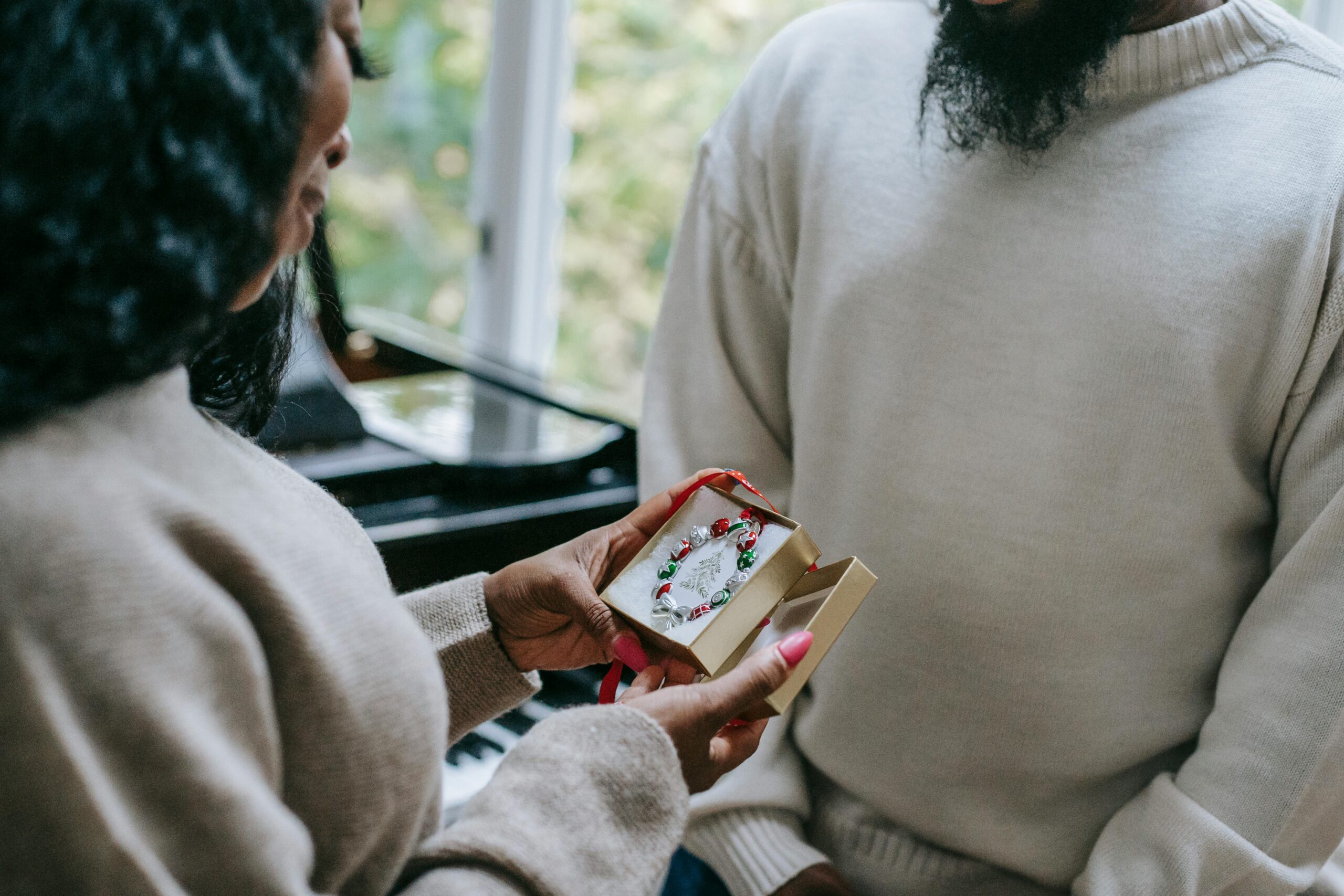 A couple exchanging a jewelry gift indoors, showcasing love and celebration.